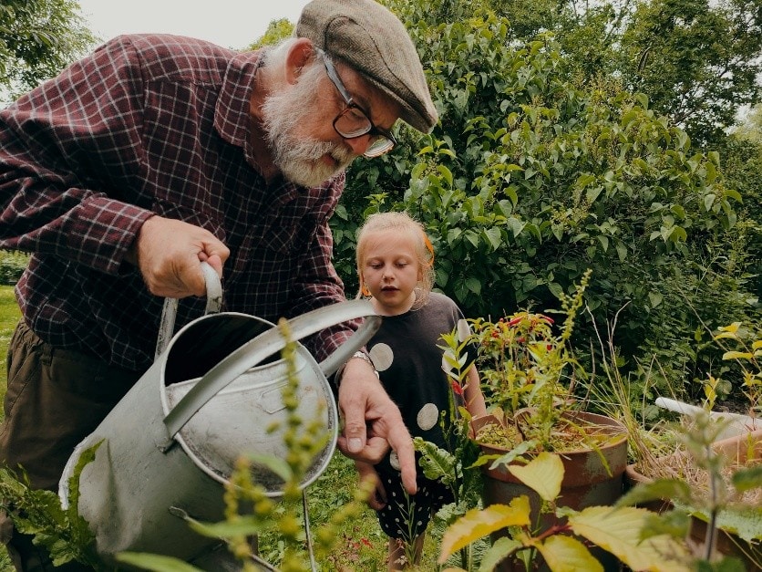 Älterer Herr beim Gießen der Pflannzen